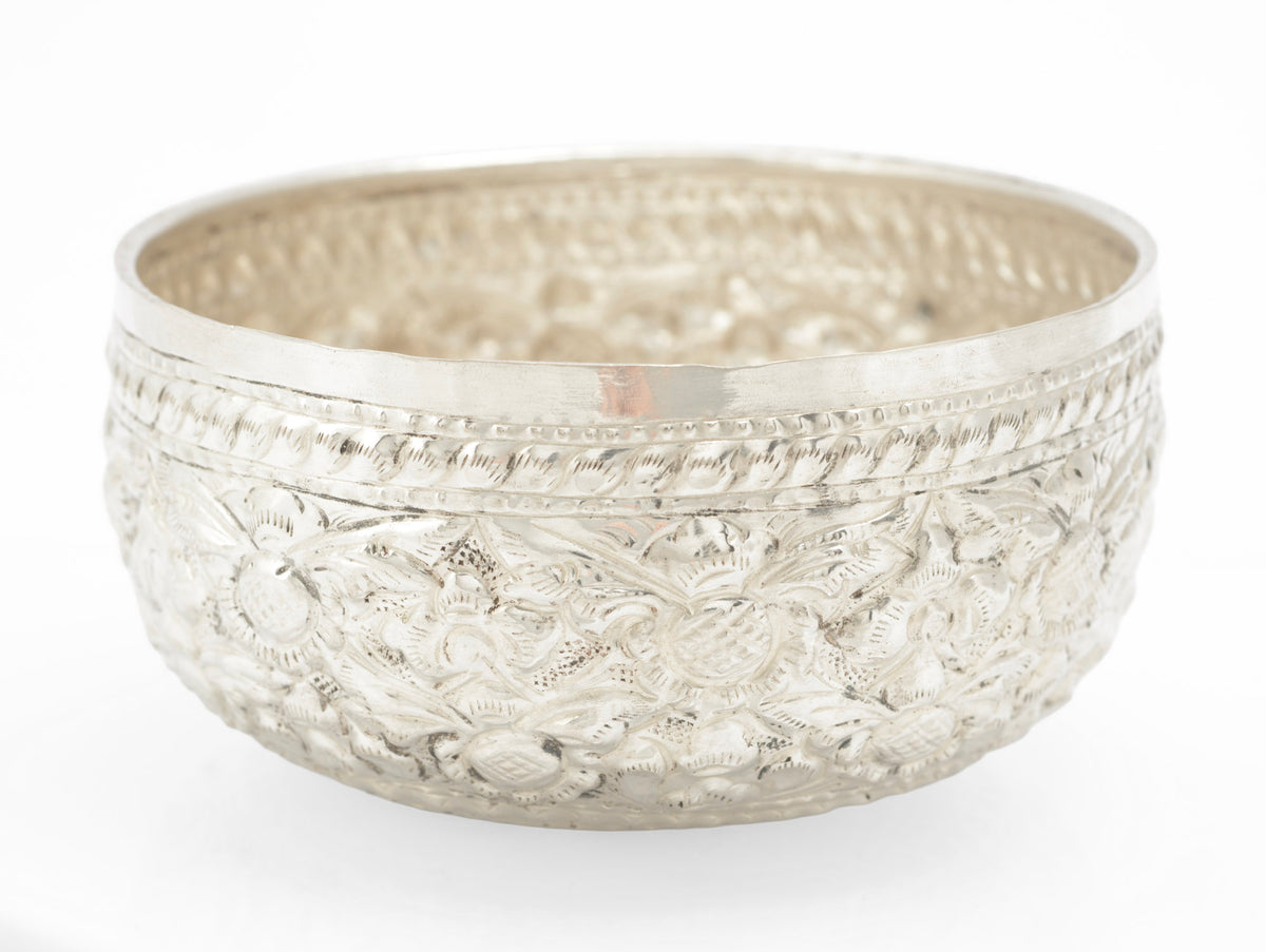 Detail of raised and chased floral decoration on a handmade Thai silver offering bowl