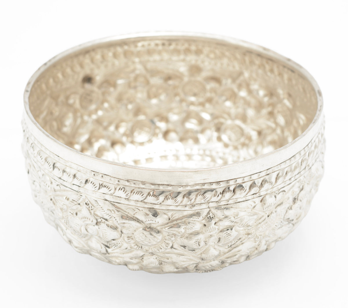 Interior of handmade Thai silver offering bowl showing hammered texture and decorated rim
