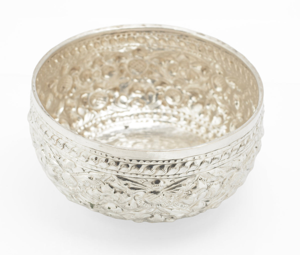 Side detail of a mid century Thai silver offering bowl with dense floral repousse work