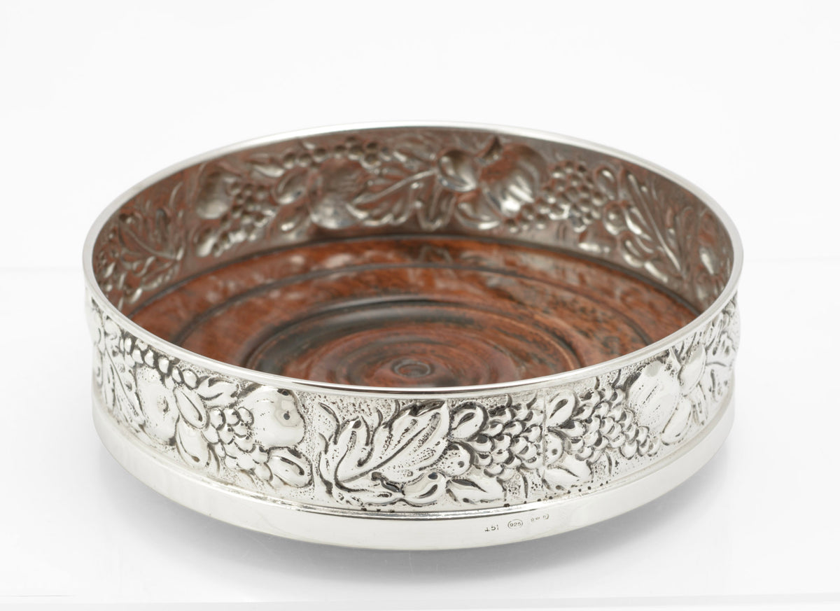 Sterling silver repousse bottle coaster by Falsini Ferruccio Florence, grapevine and fruit band, turned hardwood base - view from above and side