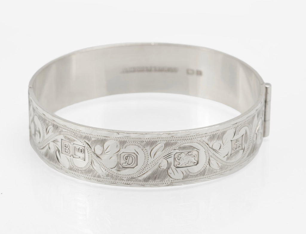 Vintage sterling silver hinged bangle by Bracelon Ltd Birmingham 1978, engraved scrolling foliage with feature hallmarks - front view