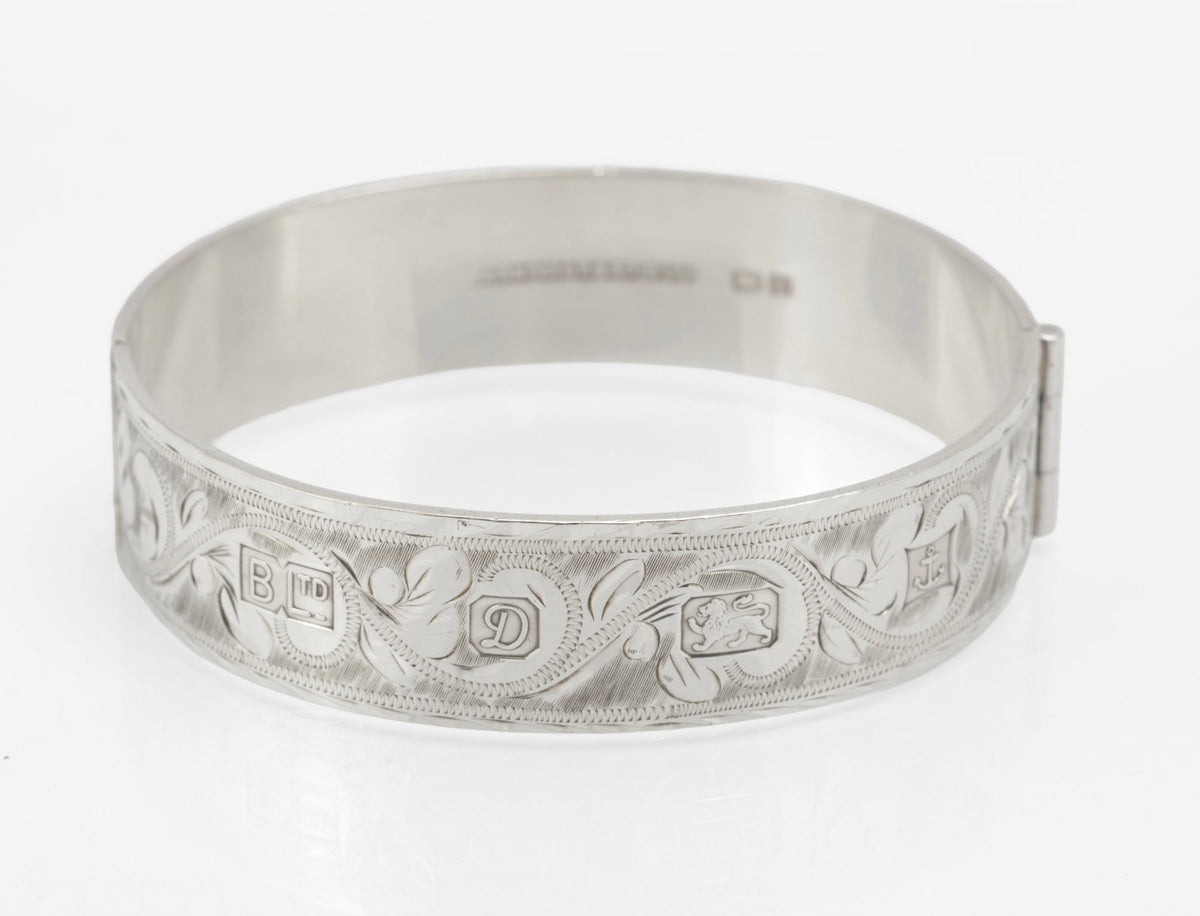 Vintage sterling silver hinged bangle by Bracelon Ltd Birmingham 1978, engraved scrolling foliage with feature hallmarks - front view
