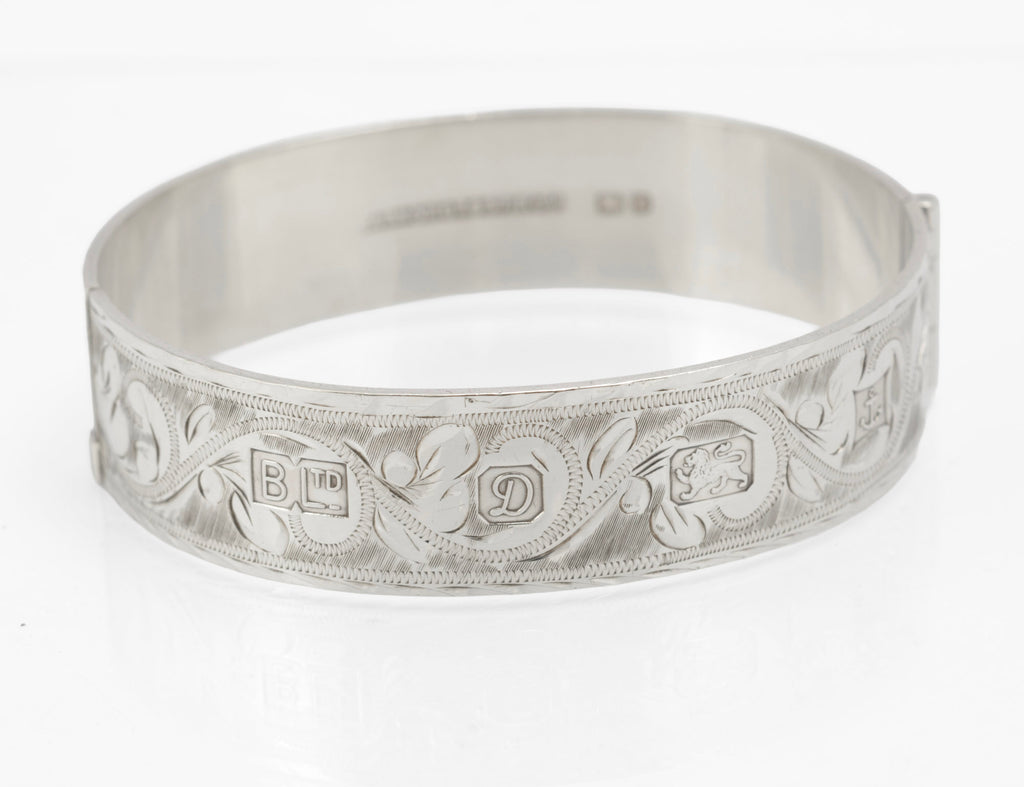 Sterling silver Bracelon Ltd bangle, angled view showing engraved scrolling foliage and feature hallmark cartouches