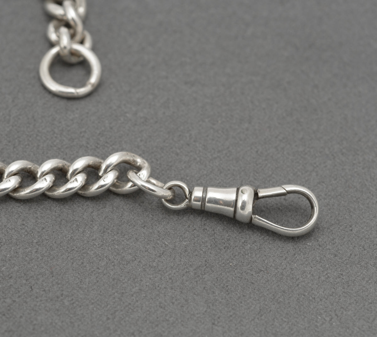 Antique sterling silver double Albert watch chain laid out with T bar, watch hook and terminal jump ring