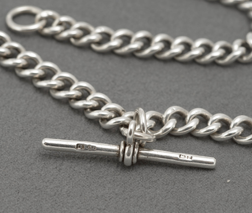 Close view of the watch hook and lion passant marks on an antique sterling silver Albert chain