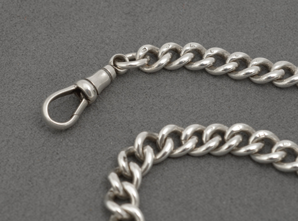 Close view of the central T bar and chain connection on an antique sterling silver Albert chain