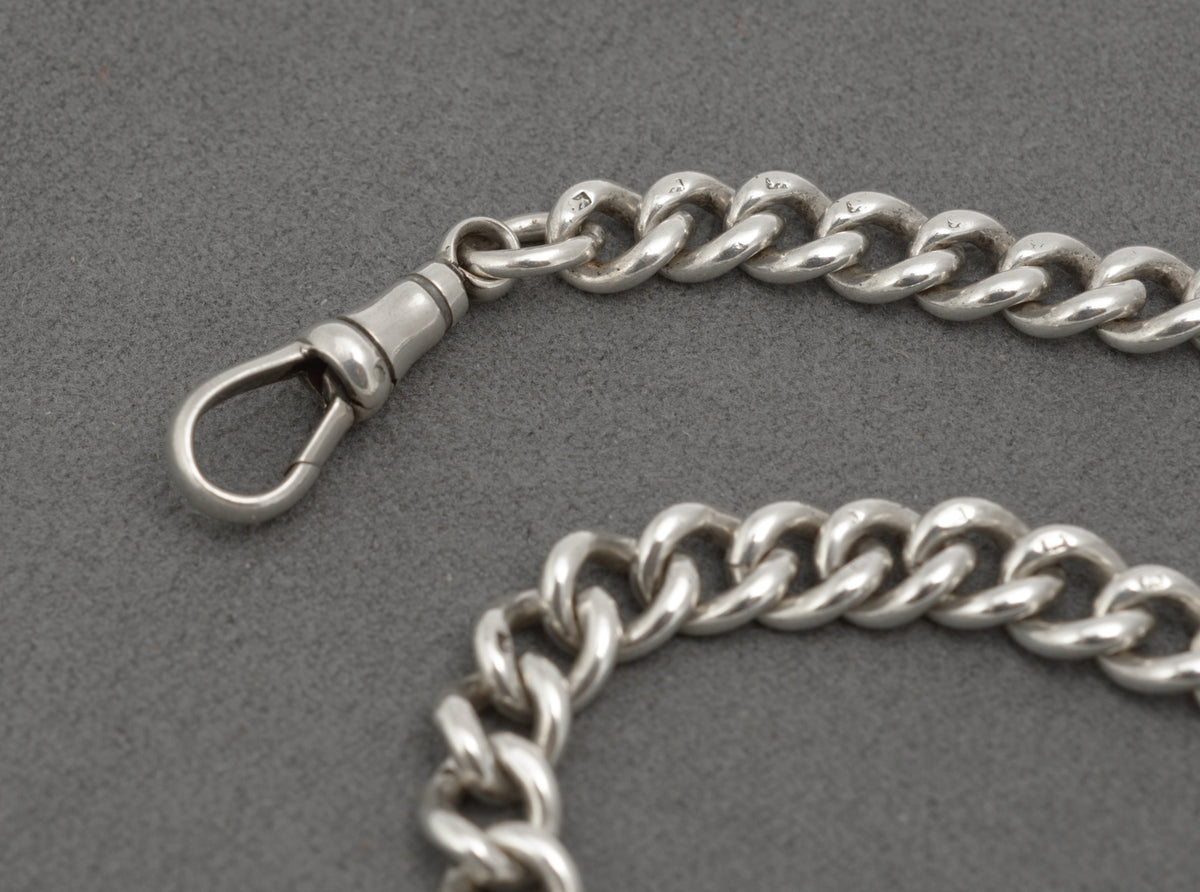 Close view of the central T bar and chain connection on an antique sterling silver Albert chain