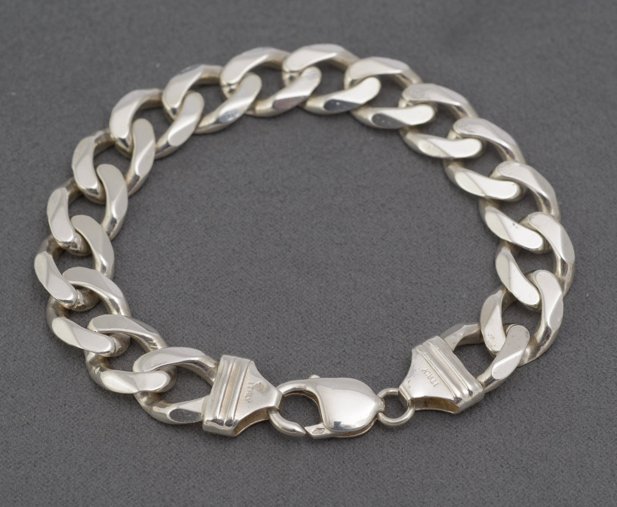 Italian sterling silver flat curb link bracelet laid out with lobster clasp open