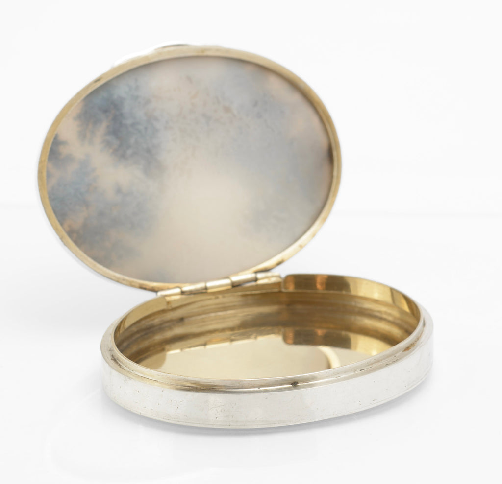 Antique sterling silver oval moss agate box shown on a grey background with the hinged lid closed