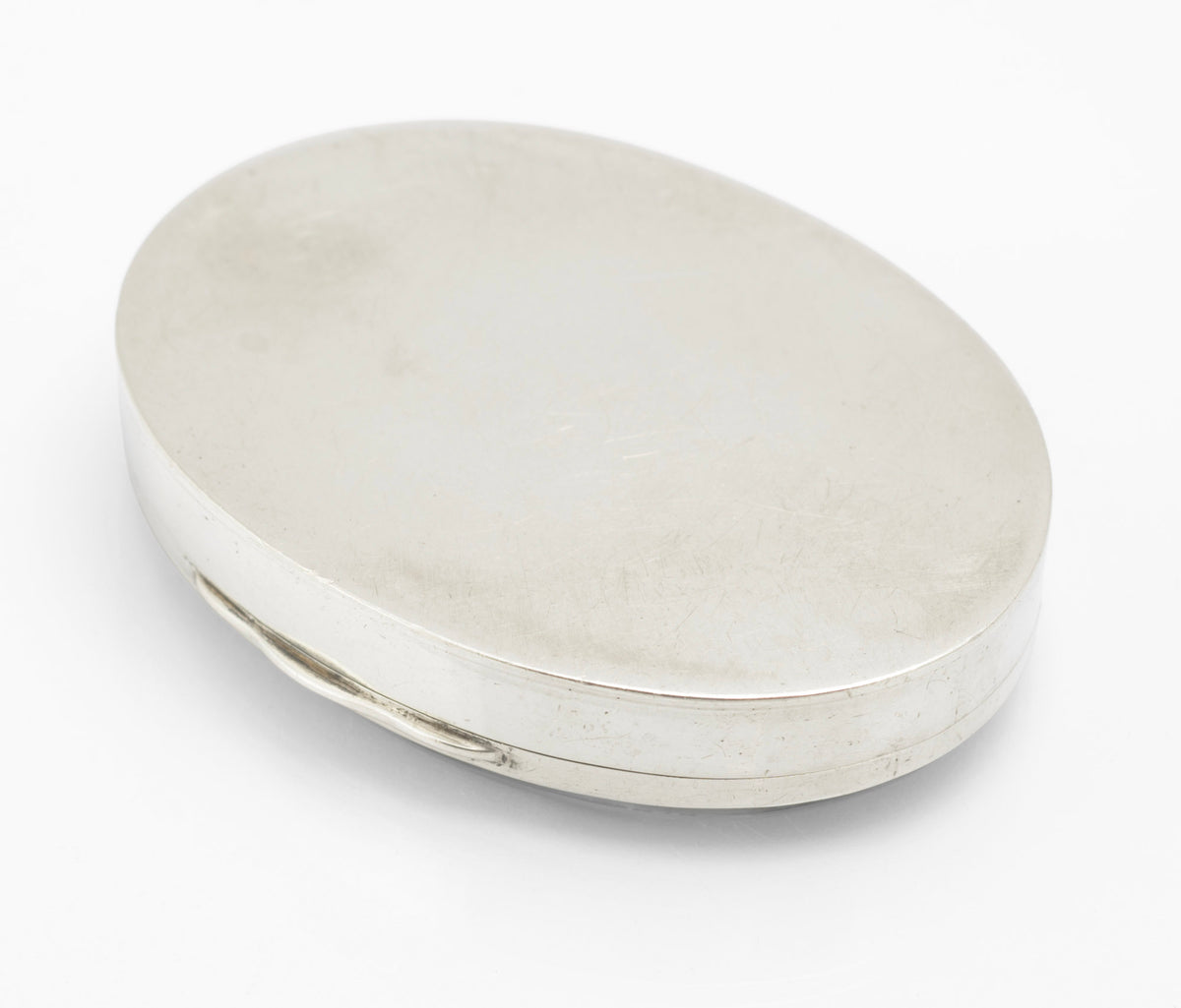 Antique sterling silver oval box shown from the hinge side with the moss agate cabochon lid closed