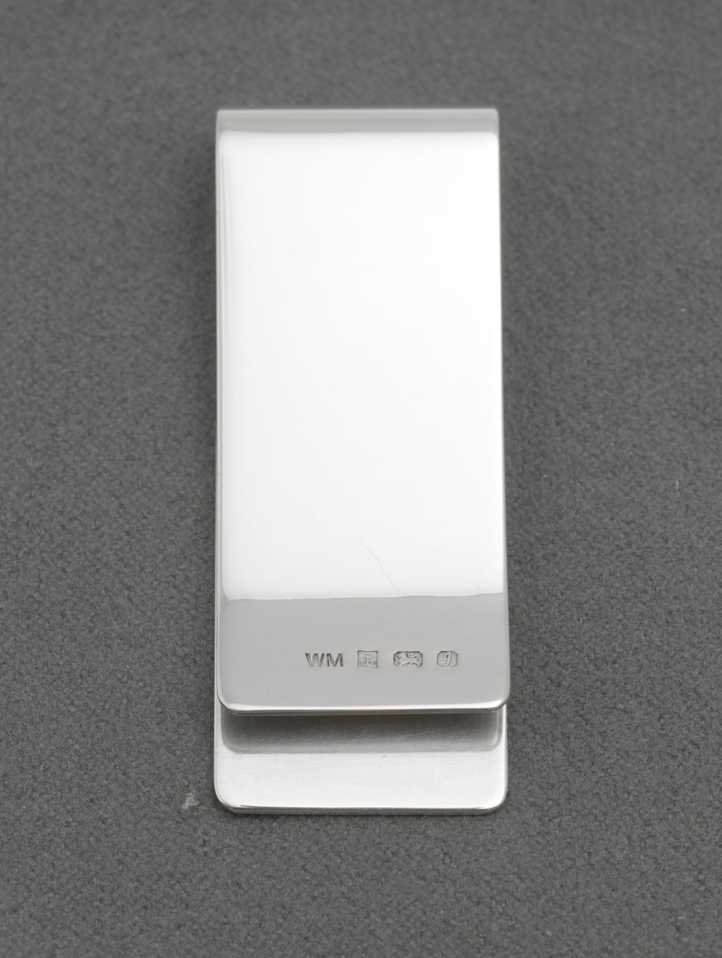 Side view of vintage sterling silver money clip showing its folded clip form and polished reverse