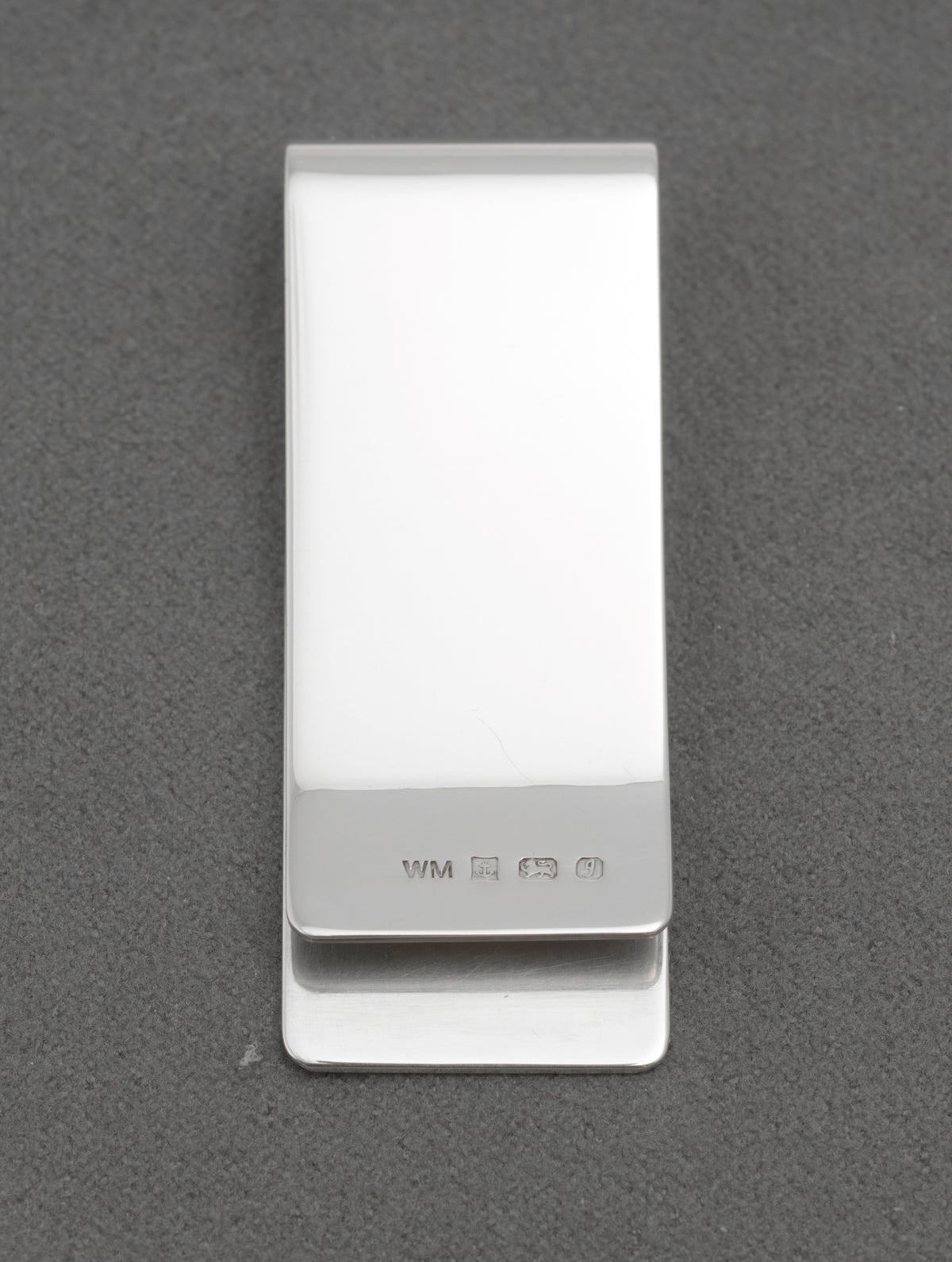 Side view of vintage sterling silver money clip showing its folded clip form and polished reverse