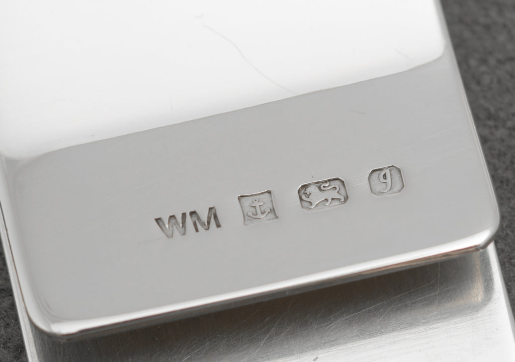 Front view of vintage sterling silver money clip with radial engine turning and plain circular cartouche