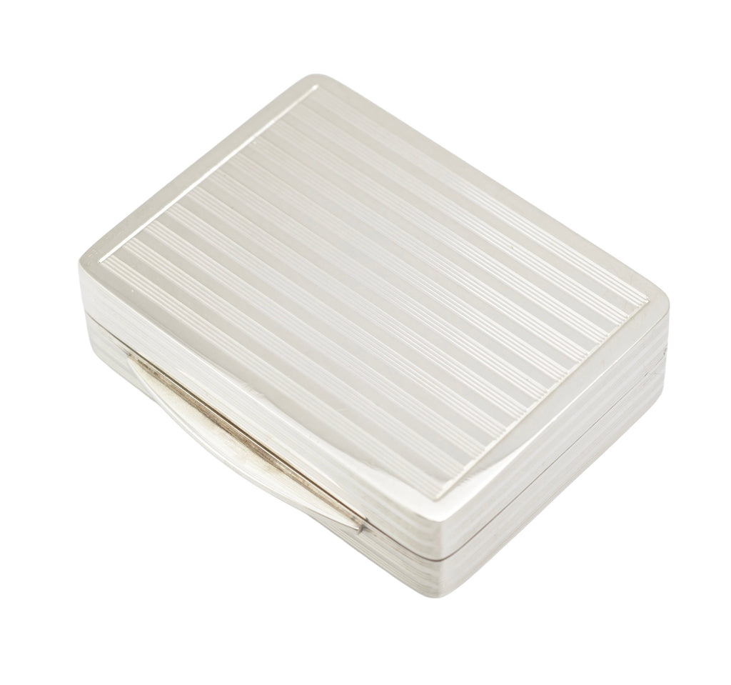 Top view of vintage sterling silver pill or snuff box with geometric reeded border and vacant cartouche