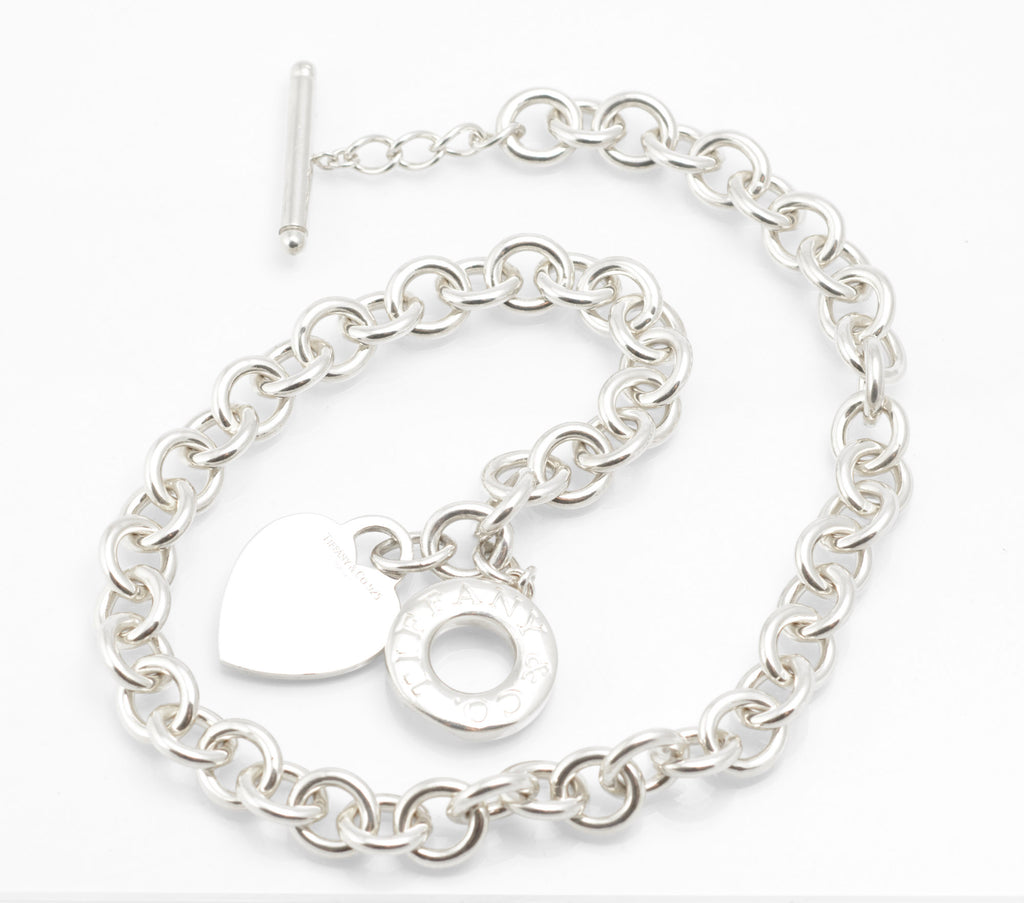 Close view of the Tiffany sterling silver heart tag, circular toggle disc and T bar on the soft pouch