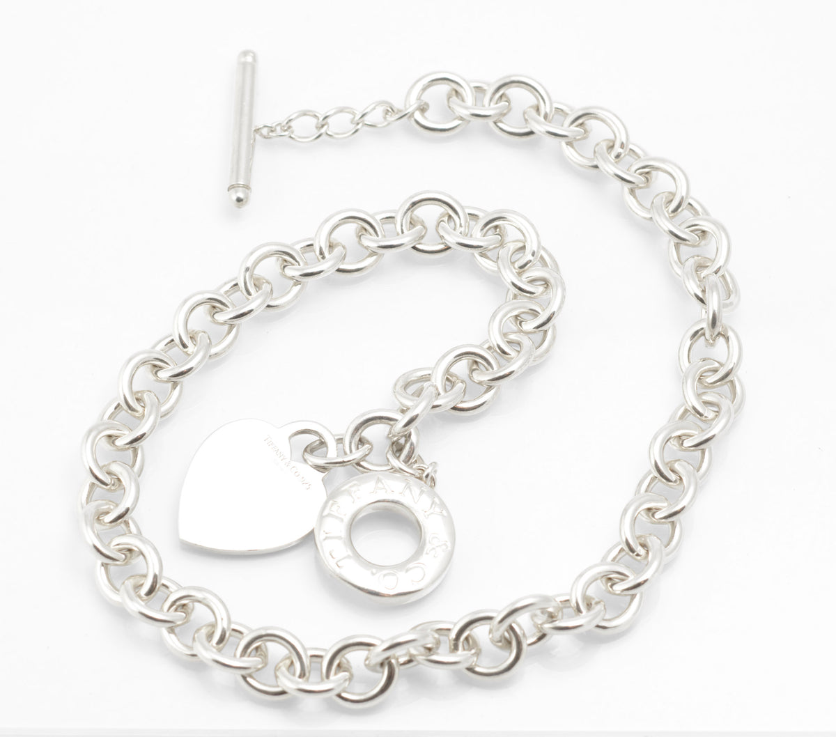 Close view of the Tiffany sterling silver heart tag, circular toggle disc and T bar on the soft pouch
