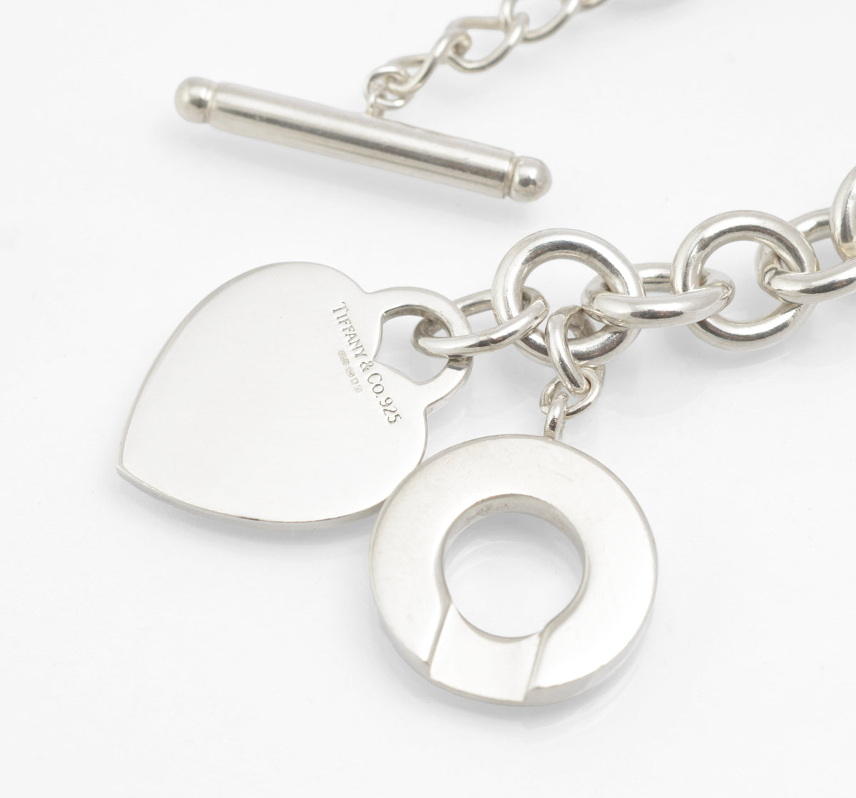 Close view of the circular Tiffany and Co sterling silver toggle disc and heart tag
