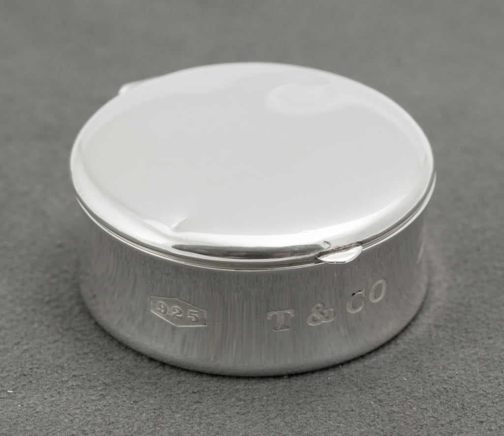 Closed front view of vintage Tiffany & Co sterling silver 1837 circular pill box with concave profile