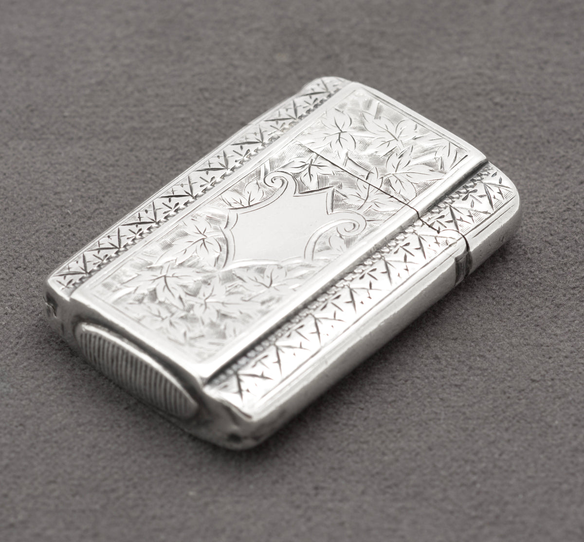 Closed Victorian sterling silver vesta case with rounded corners and detailed foliate engraving