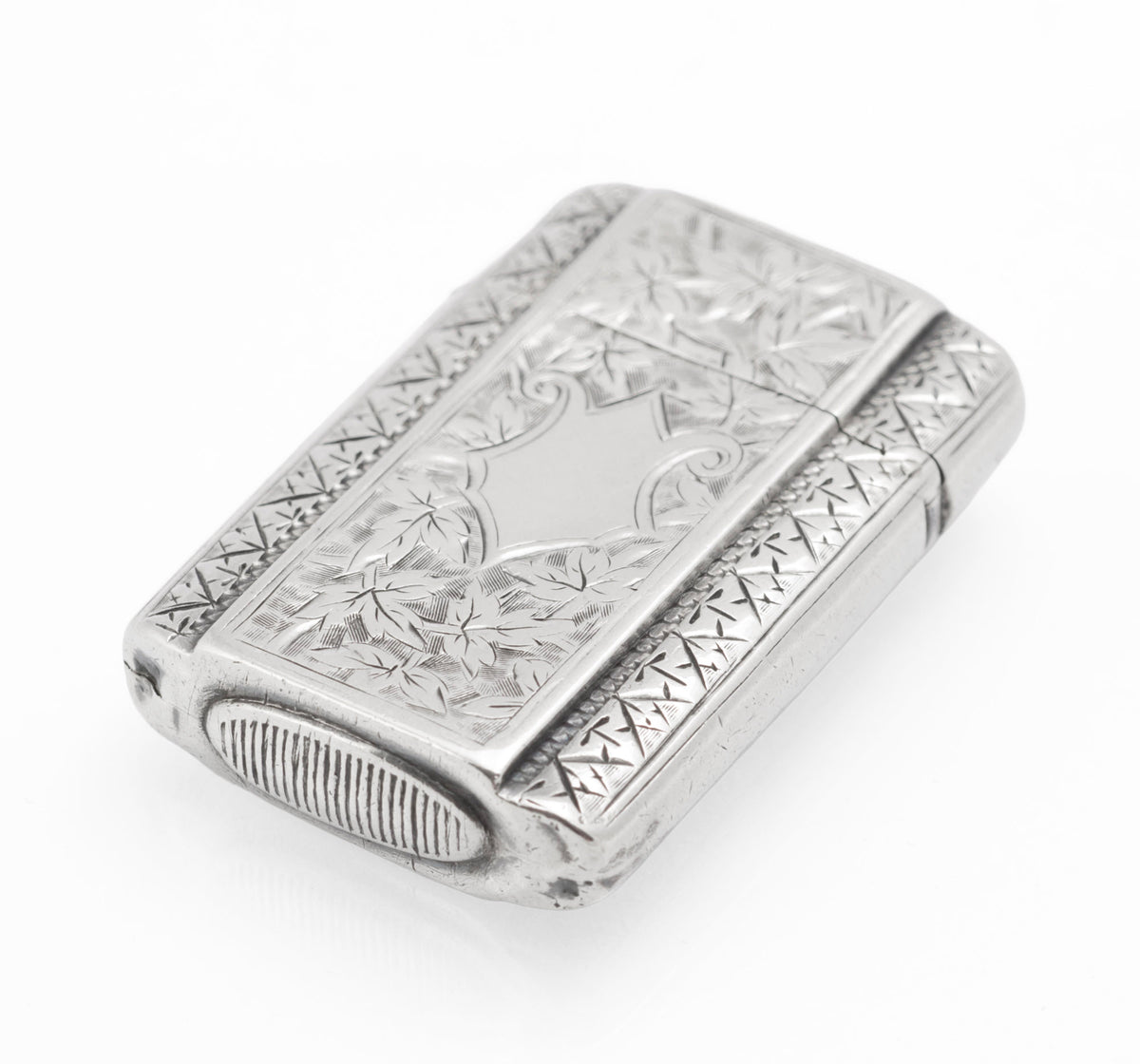 Small Victorian sterling silver vesta case with chased foliate decoration, vacant cartouche and ribbed striker