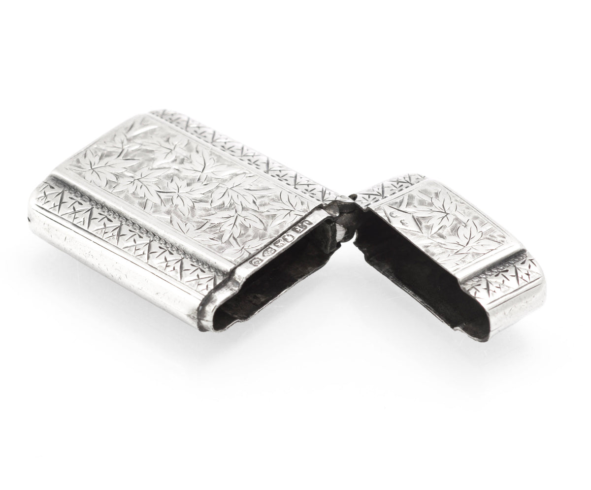 Open antique sterling silver vesta case showing the hinged cap and dark interior
