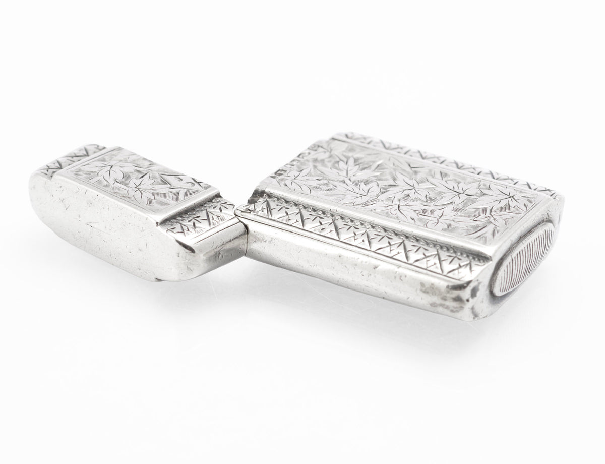 Open silver vesta case showing the hinge, chased panels and rounded rectangular form