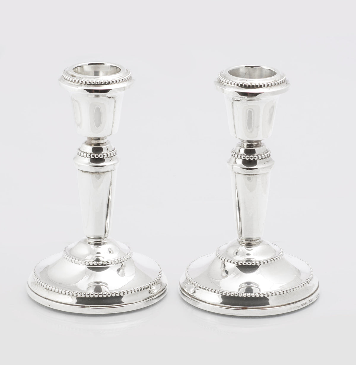 Pair of vintage sterling silver candlesticks by W I Broadway and Co with beaded borders and weighted circular bases