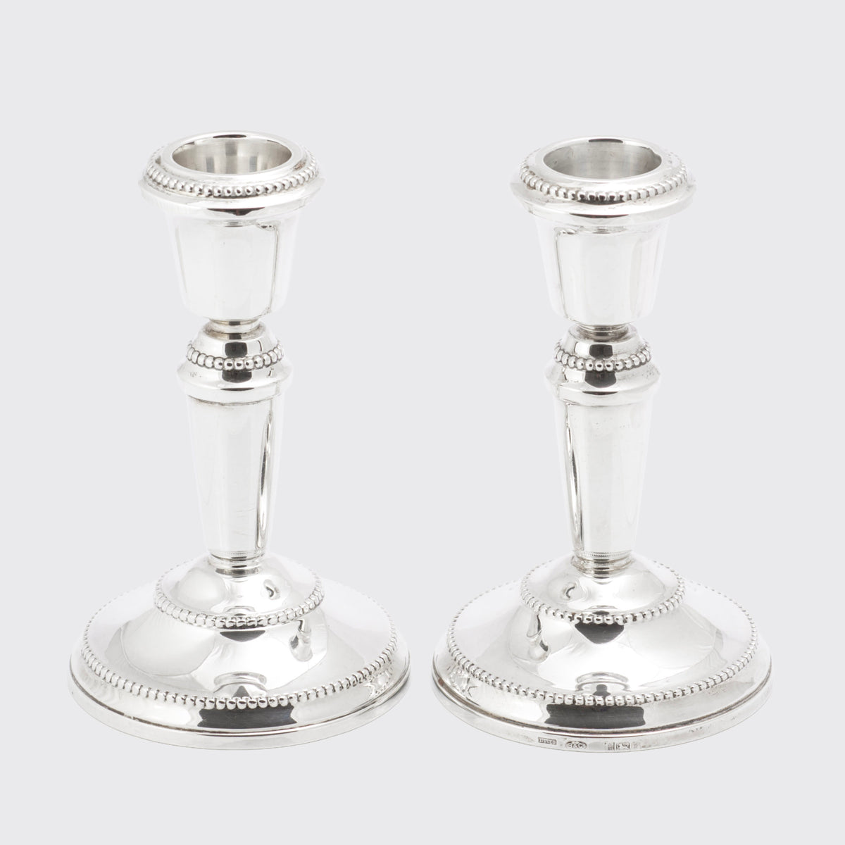 Decorative view of the vintage sterling silver candlesticks showing beaded base and nozzle borders