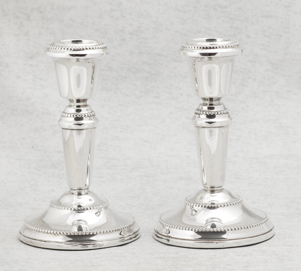 Matching pair of vintage sterling silver candlesticks with broad circular bases and classical form