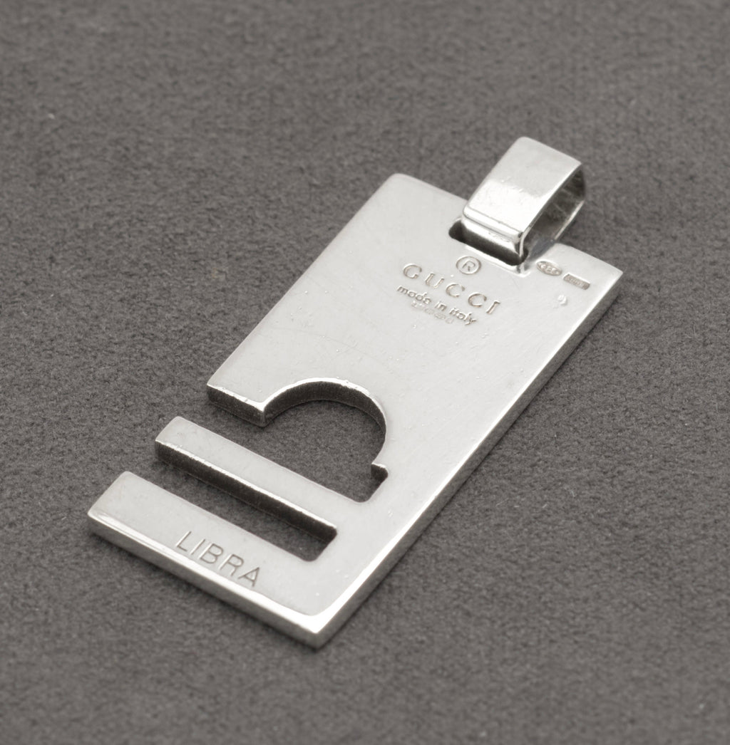 Angled view of Gucci silver Libra pendant with London assay marks beside the suspension loop - C3110