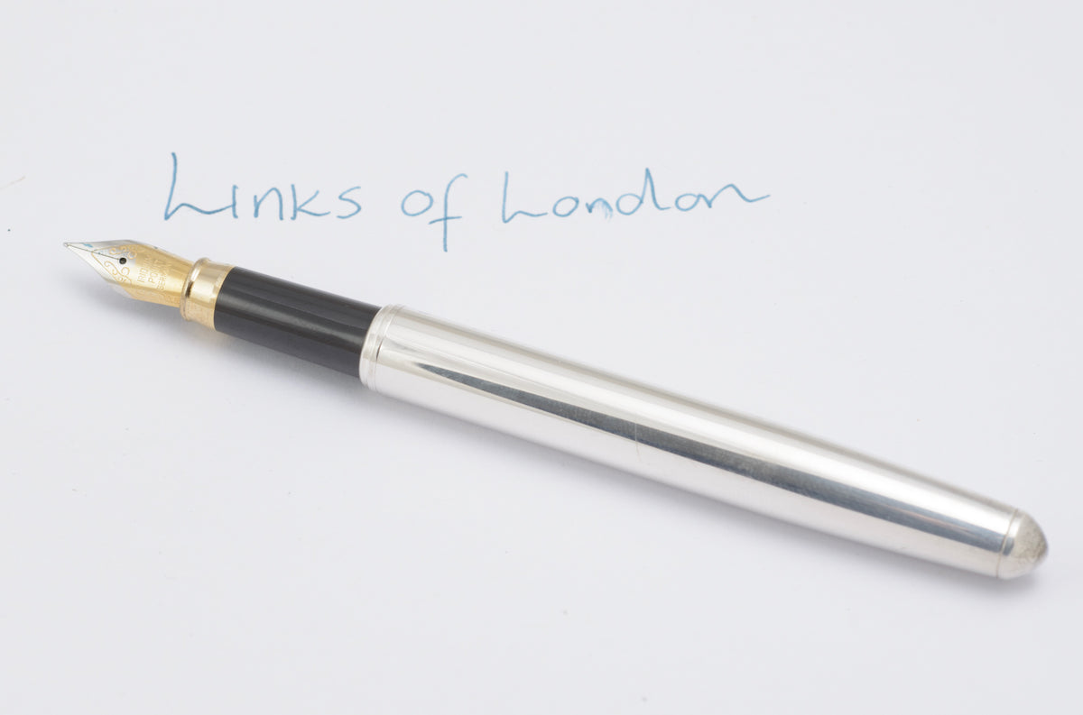 Uncapped Links of London silver plated fountain pen showing the black grip and gold tone nib
