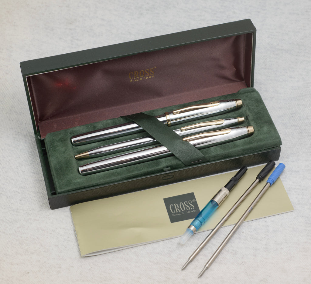 Boxed Cross Medalist writing set with three chrome and gold tone pens, original case, paperwork, converter, cartridge and spare refills