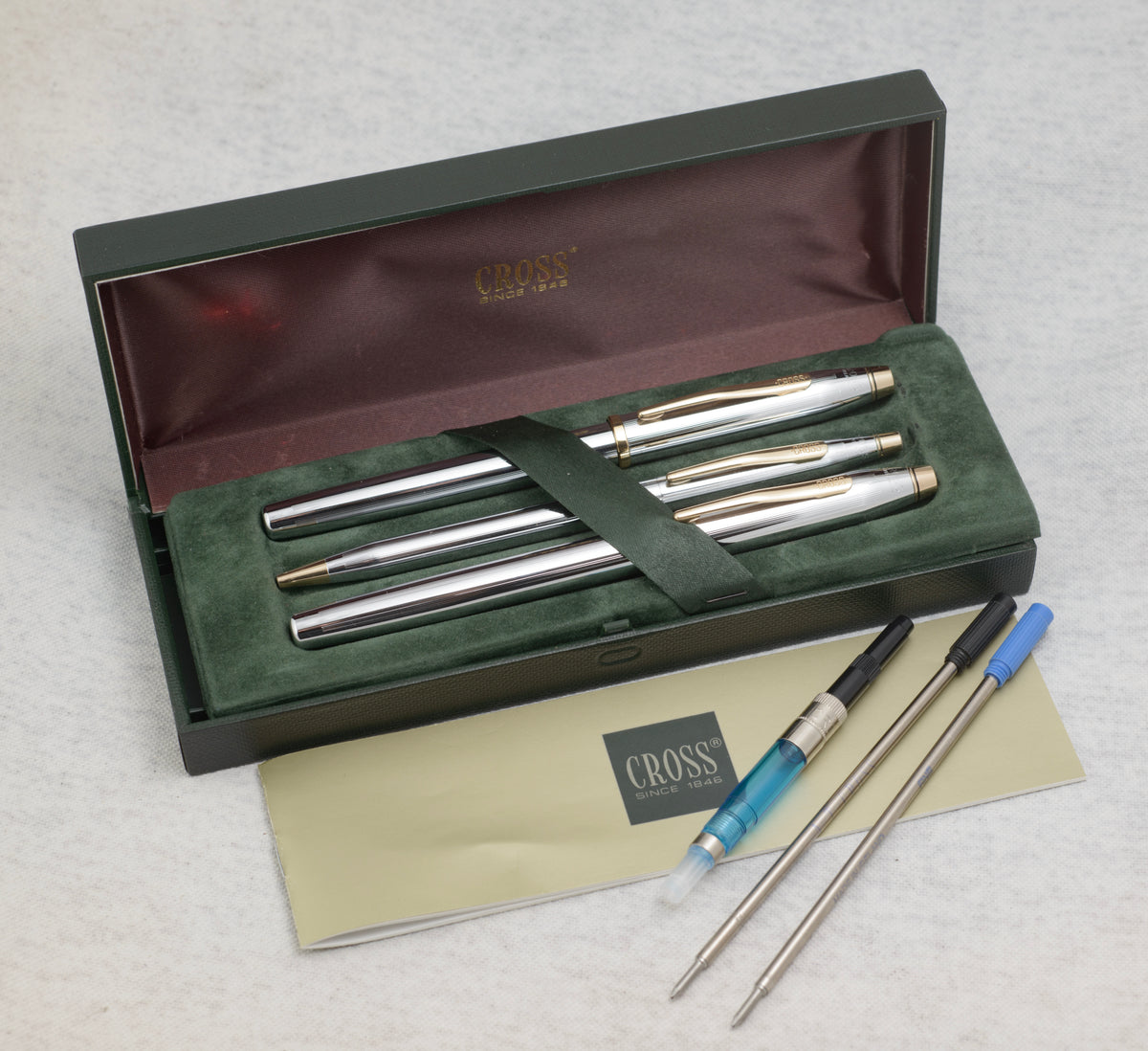 Boxed Cross Medalist writing set with three chrome and gold tone pens, original case, paperwork, converter, cartridge and spare refills