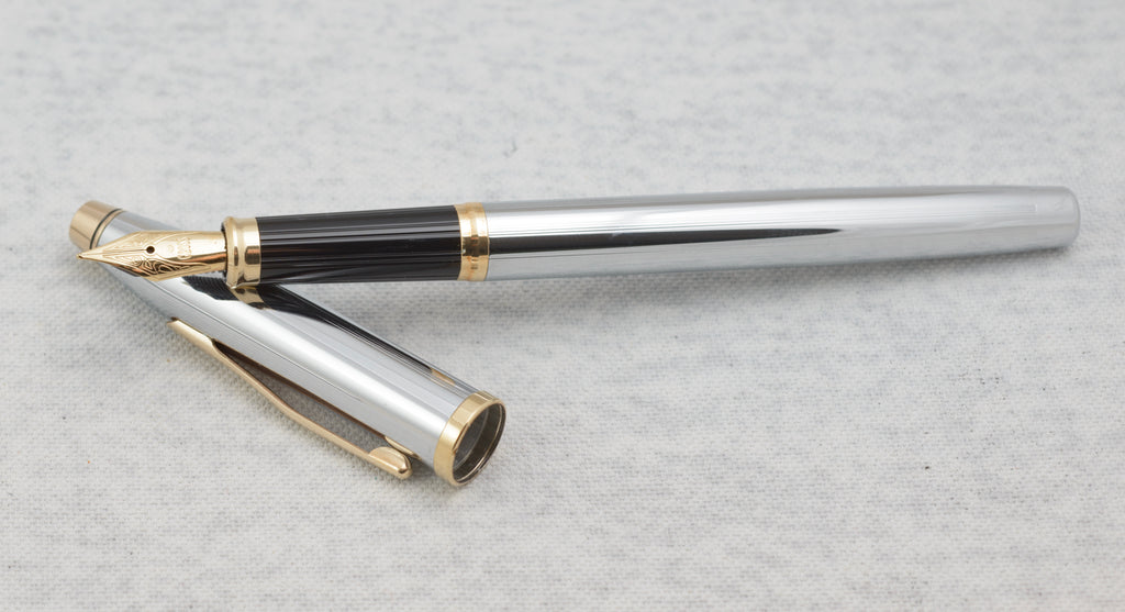 Cross Century II fountain pen with black grip, decorative gold tone nib and polished chrome cap