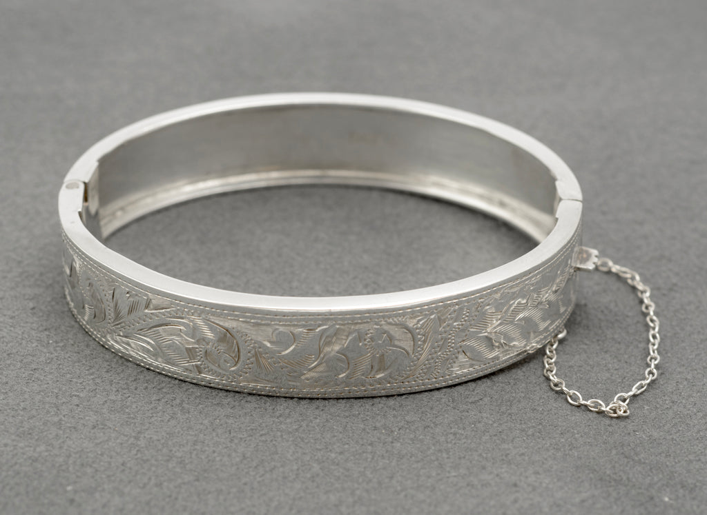 Vintage sterling silver bangle by N. C. Reading & Co, showing the engraved floral front and attached safety chain