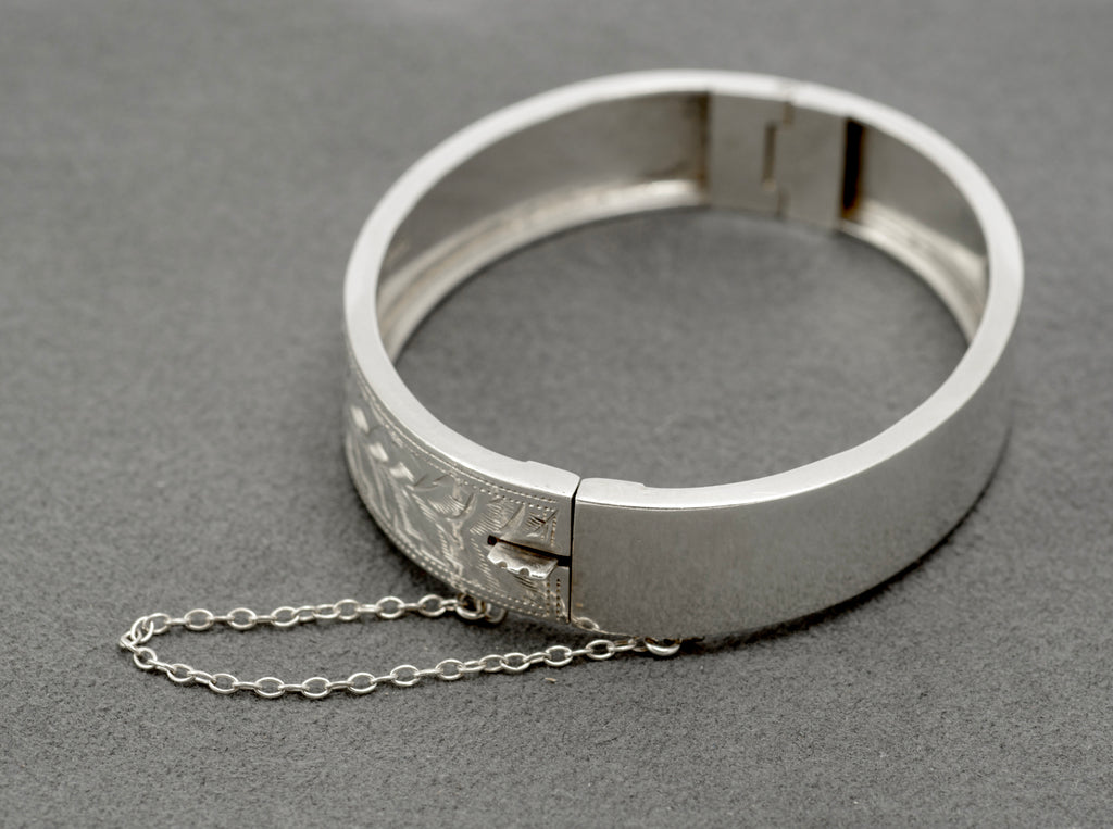 Interior of the hinged sterling silver bangle, showing the slide clasp and safety chain