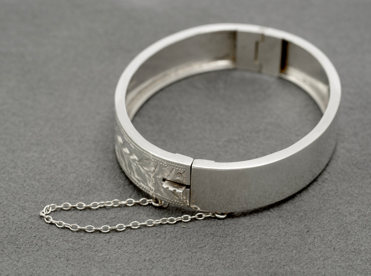 Interior of the hinged sterling silver bangle, showing the slide clasp and safety chain