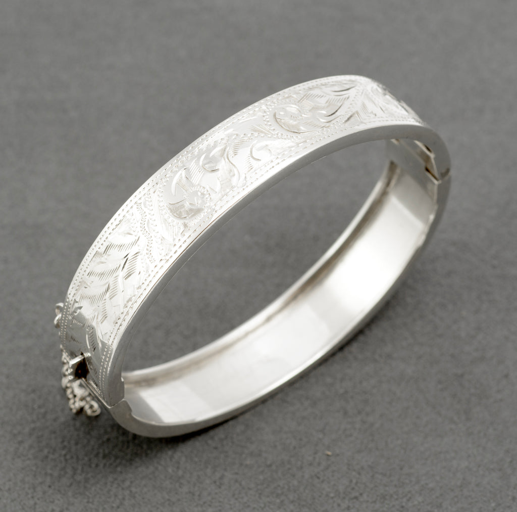 Close view of the raised engraved scrollwork and dotted borders on the silver bangle