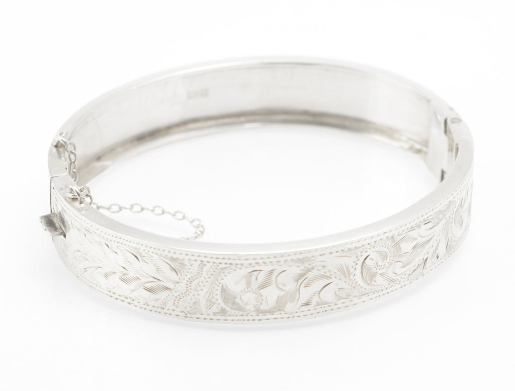 Open inner view of the hinged silver bangle with its attached safety chain