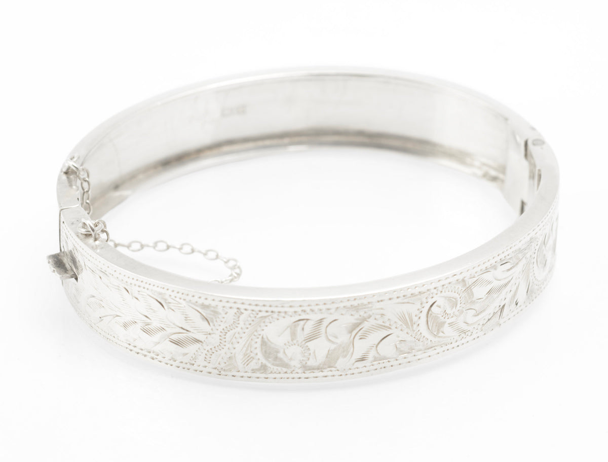Open inner view of the hinged silver bangle with its attached safety chain