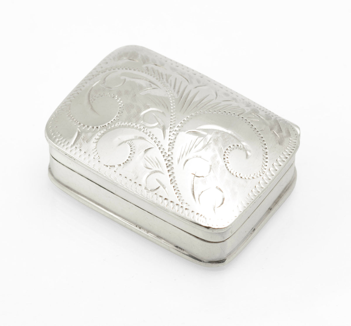 Engraved lid of the sterling silver pill box with scrolling acanthus style foliage