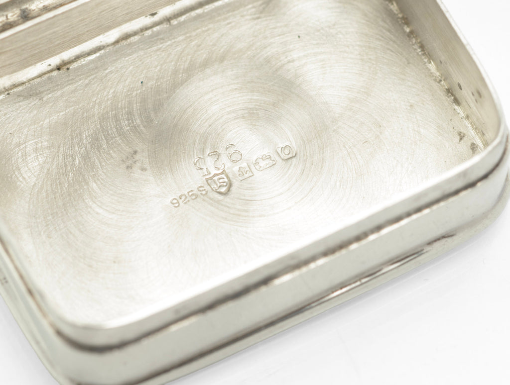 Open silver pill box showing the plain inner lid and polished interior