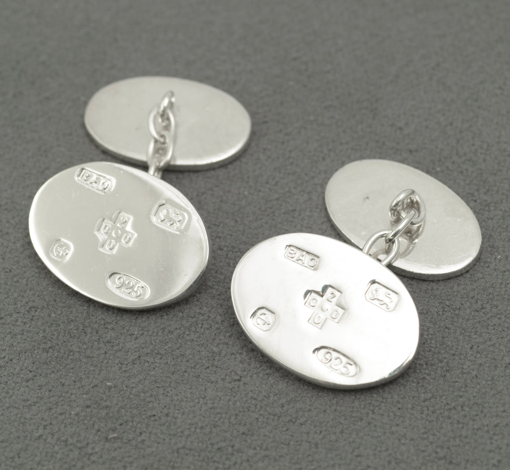 Reverse view of both cufflinks showing the plain polished oval panels and short chain links