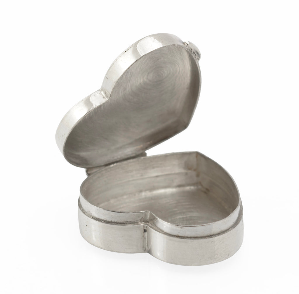 Heart shaped silver box with its hinged lid open, showing the plain silver interior