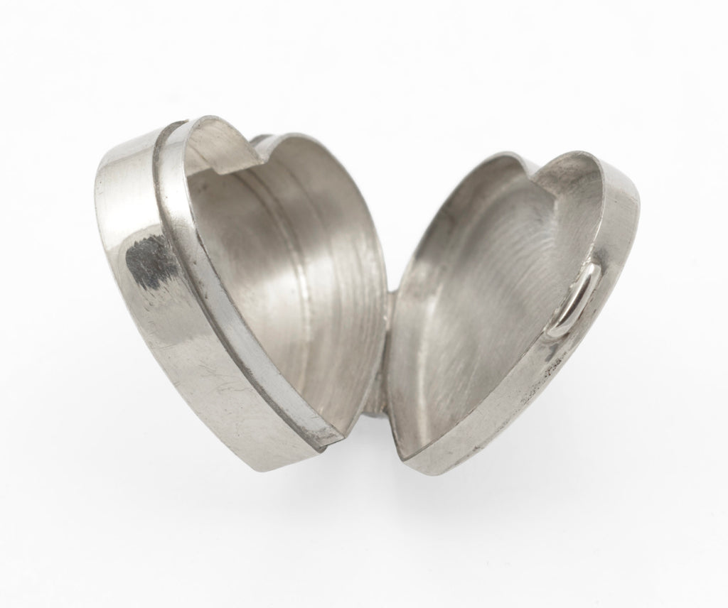 Side view of the open sterling silver heart box showing the interior of both lid and base