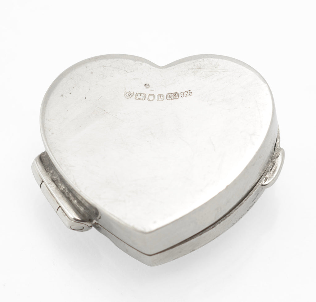 Underside of the silver heart box showing hallmark stamps and light surface scratching