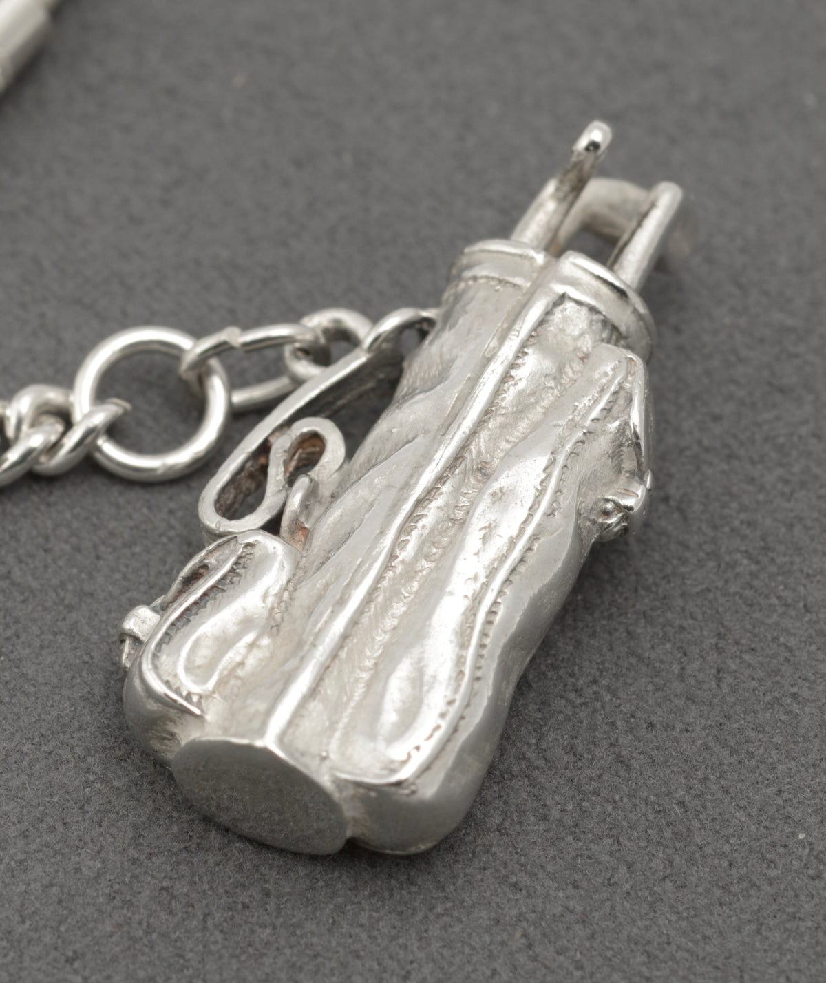 Close view of the silver golf bag charm showing clubs, straps and moulded pockets