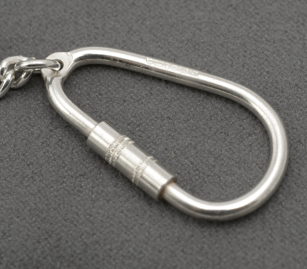 Close view of the karabiner style silver key holder with its screw barrel closed