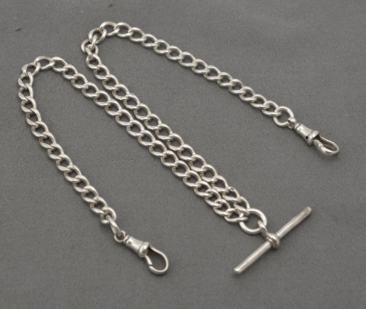 Edwardian silver double Albert watch chain coiled with central T bar and two swivel dog clips
