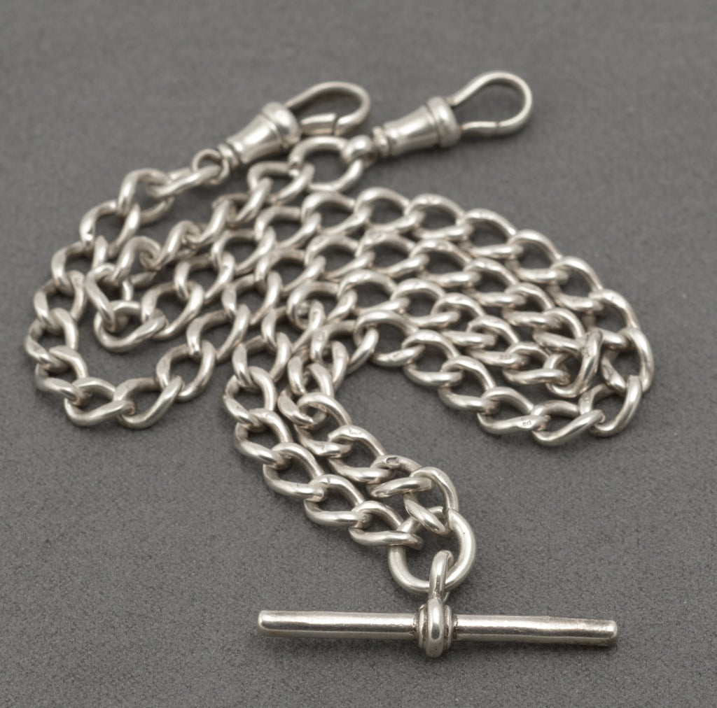 Close detail of the rounded silver curb links and rubbed individual link marks